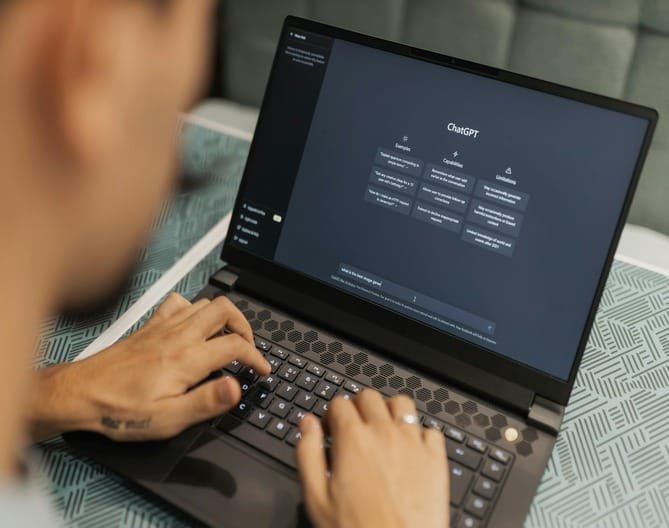Person using a laptop with ChatGPT, representing AI brand auditing.