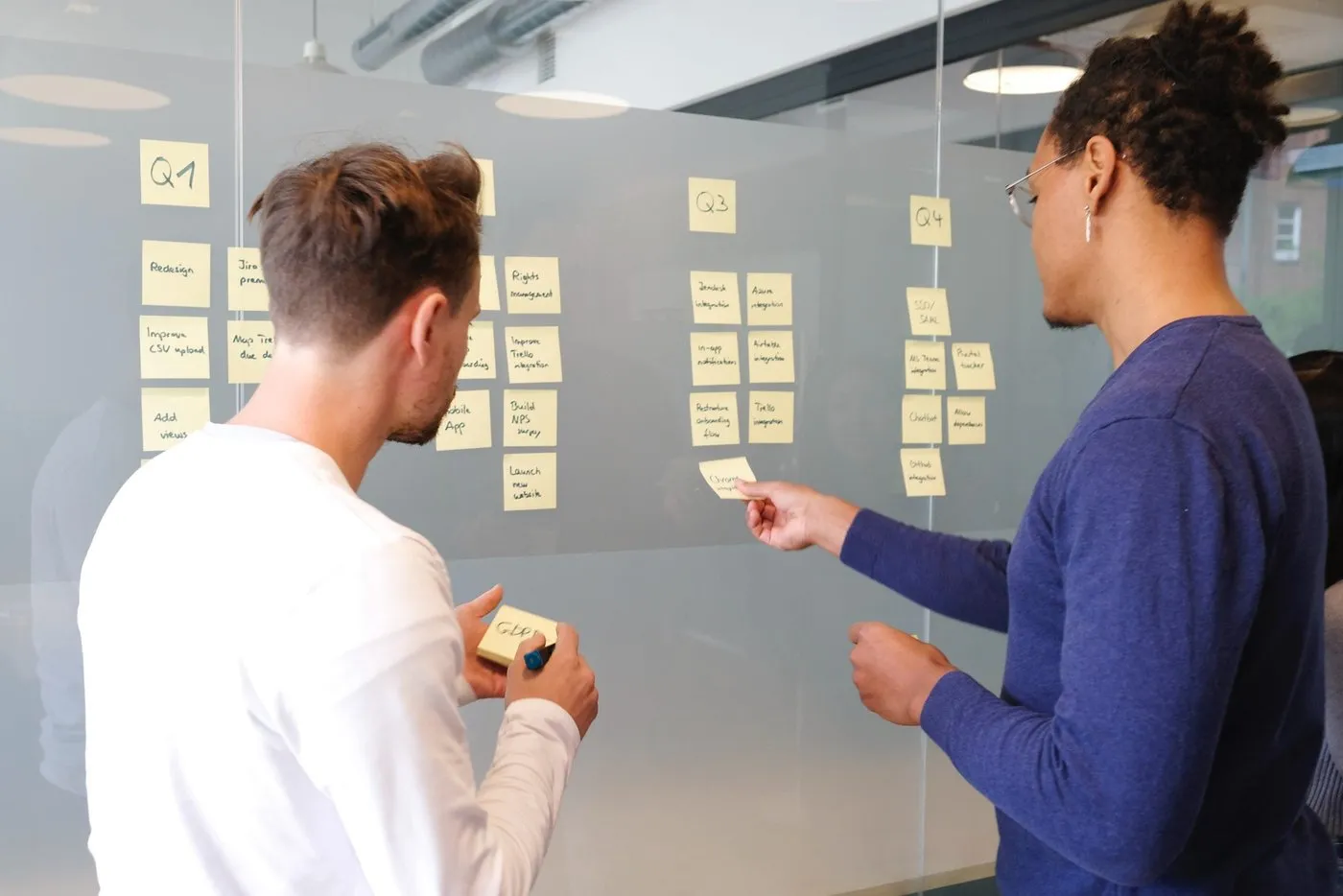 Two people brainstorm SEO strategies on sticky notes.