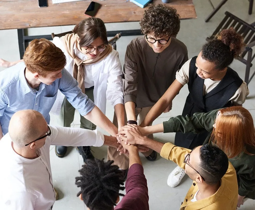The Position Digital team putting their hands together.
