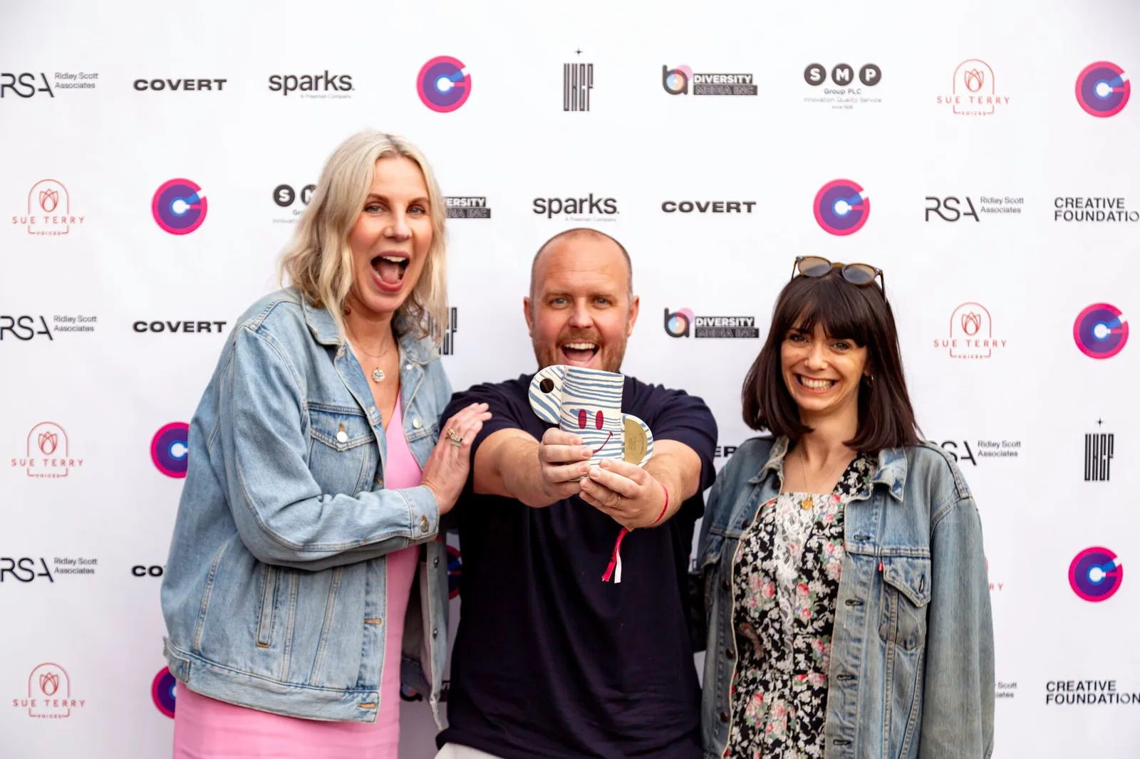 Three members of the Don’t Panic team holding an award at an awards event.