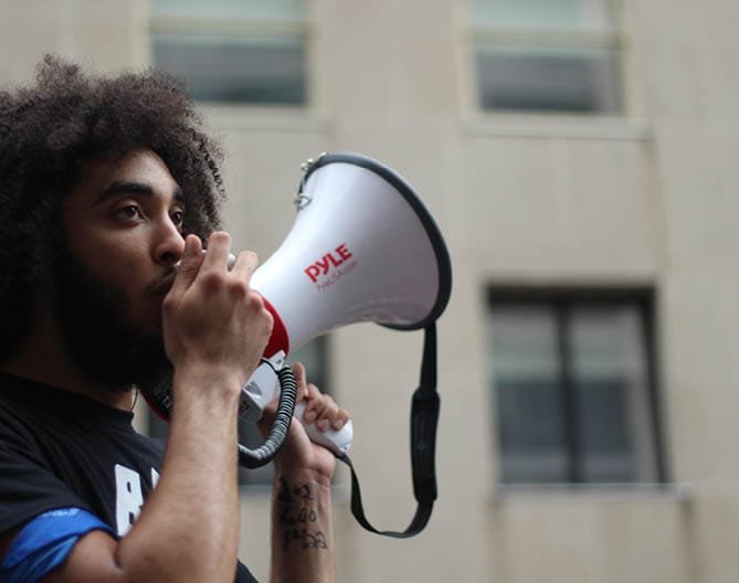 A person with a megaphone in an urban setting, symbolising digital PR and outreach.