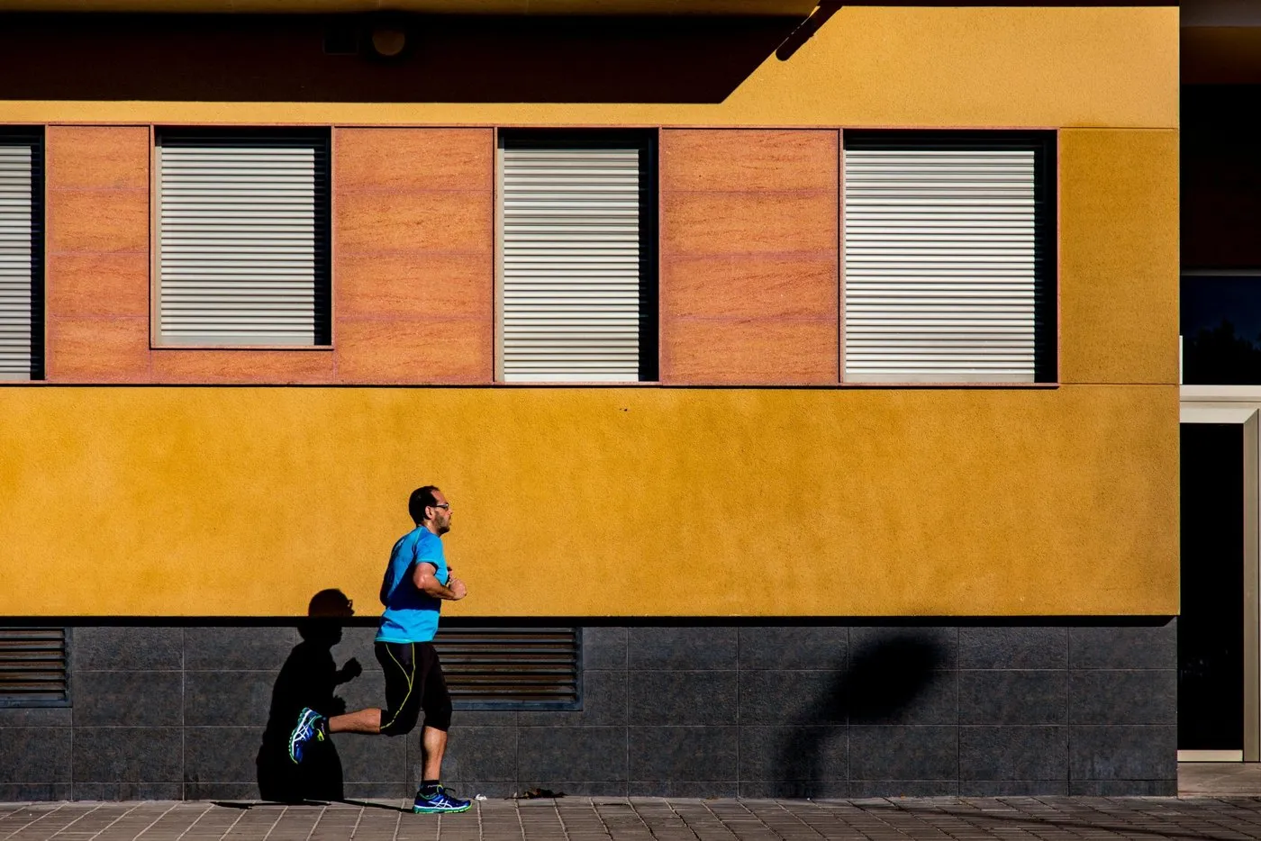 Runner in blue passing a vibrant building, symbolising fast-moving change in search.