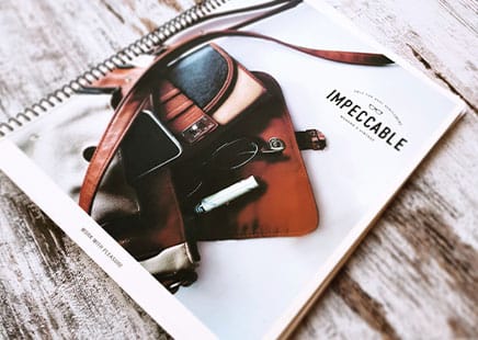 A notebook and brochure on a wooden table, symbolising long-term content evolution.