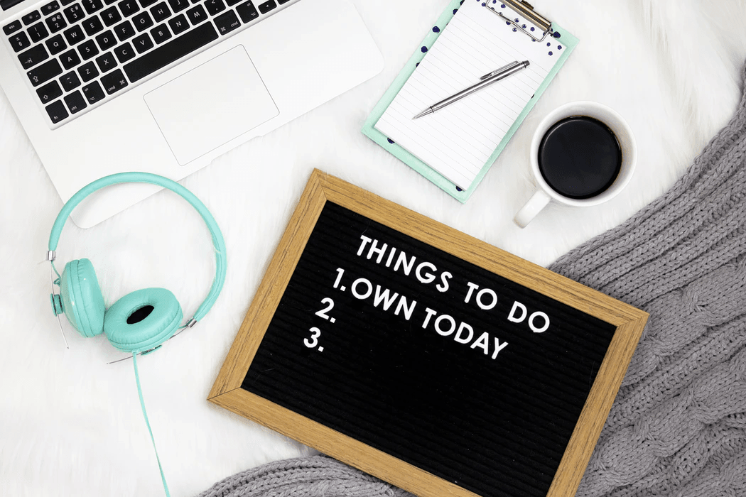 A to-do list on a board beside a laptop and coffee, symbolizing a busy day at an SEO agency for startups focused on growth.