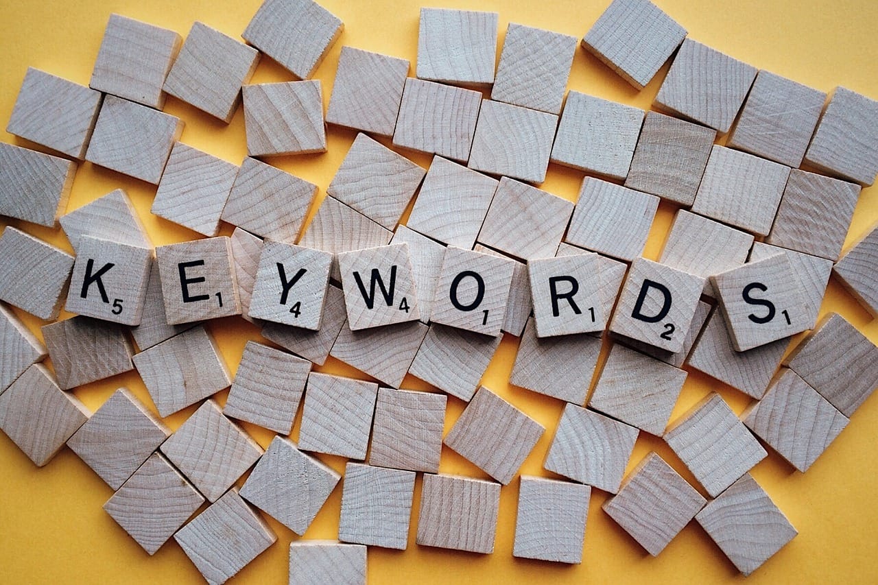 Scrabble tiles spell "KEYWORDS" on wooden blocks, symbolizing seo agency for startups, content marketing, and link building.