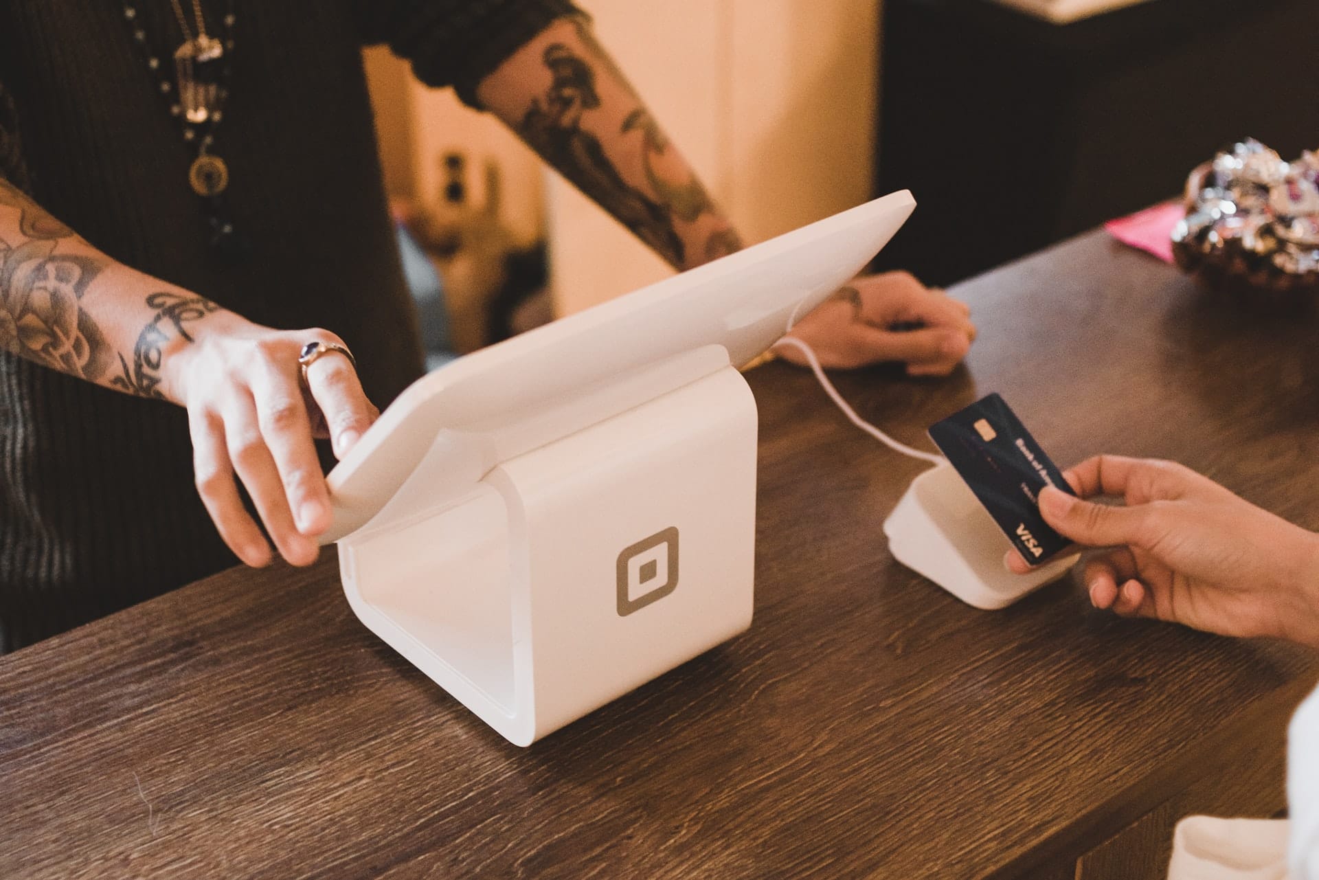 A person pays with a card at a counter, symbolizing a digital PR agency's SEO services for startups and B2B SaaS SEO agency.