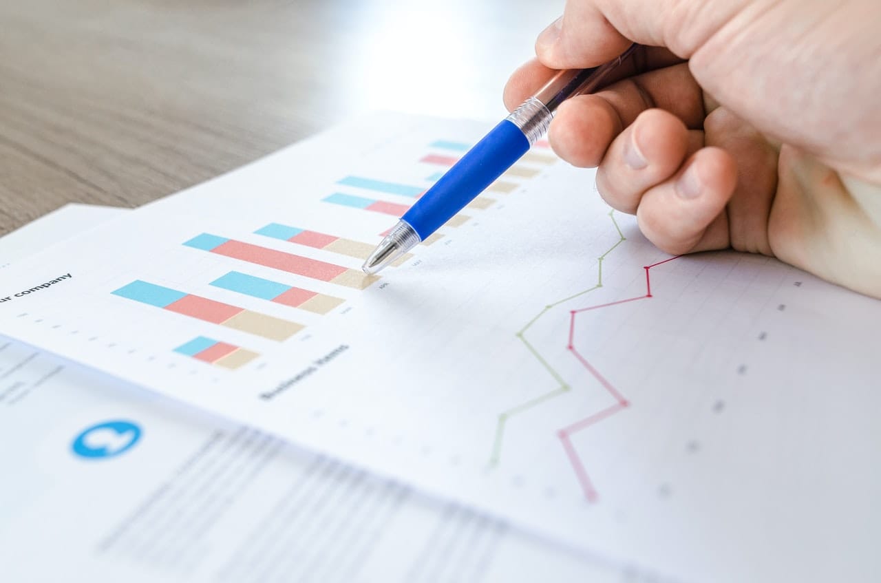 A hand points at charts, symbolizing SEO agency services for startups, B2B SaaS, and AI SEO, enhancing digital visibility.