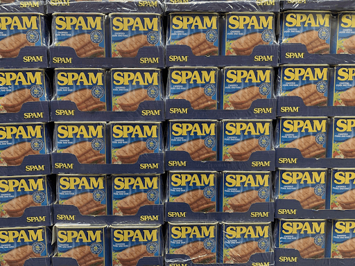 Stacked cans of SPAM in a store display, showcasing a classic product known for its versatility and long shelf life.