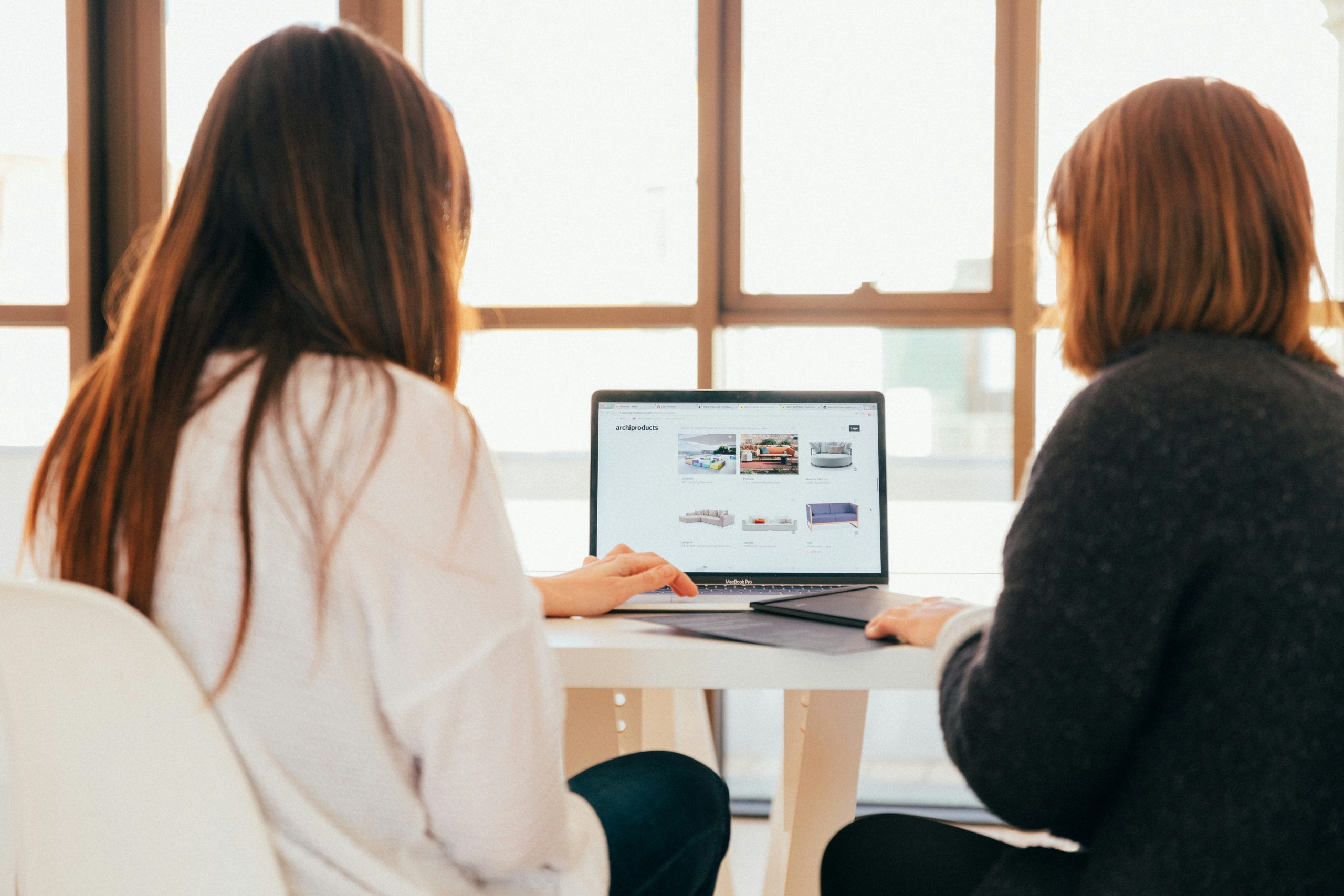 Two women looking at the laptop.